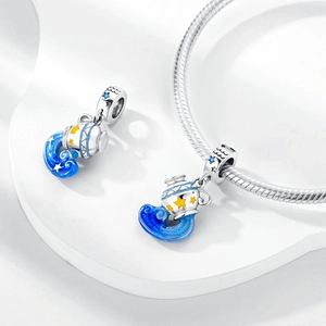 Macro detail of Aquarius zodiac charm with blue enamel and star accents on silver base