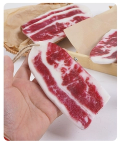 Detailed view of artificial PVC fatty beef slice with hemp rope hanger and realistic texture