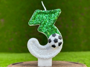 Détail macro de bougie anniversaire numéro 3 avec paillettes vertes et décor football