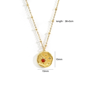 Dettaglio della collana in oro 14k con pendente a raggiera e pietra preziosa rossa