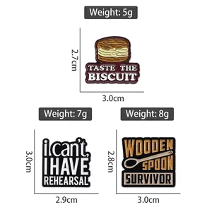 Three funny enamel lapel pins with biscuit, rehearsal and wooden spoon survivor designs