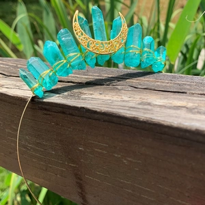 Detail of blue crystal moon headband with hand-wired raw stones on a rustic wooden base