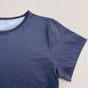 Détails de la double couture sur l'encolure et l'épaule du haut bleu marine à manches courtes