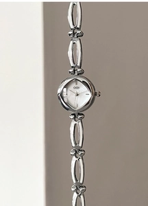 Macro view of a GEDI women's watch featuring a white mother-of-pearl dial and silver chain band