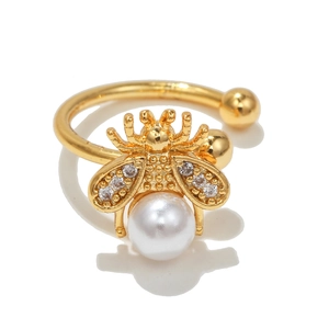 Close-up detail of golden bee ear cuff with white pearl and sparkling zircon wings