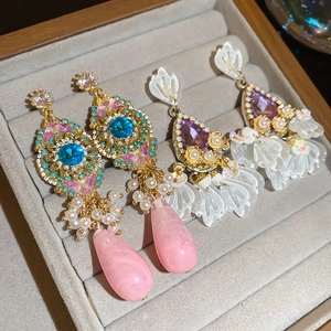 Macro detail of luxury vintage crystal earrings with pearl flower tassels in a display box