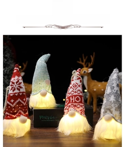 Detailed view of four glowing Christmas gnomes with warm LED lights and knit hats