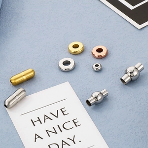 Detail view of cylindrical and spherical magnetic clasps and spacers in gold, silver and rose gold