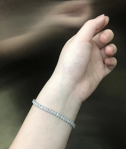 Detail of silver tennis bracelet with square-cut zircons in a classic four-prong setting