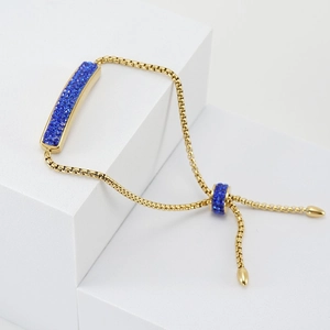 Detailed shot of 18K gold adjustable bracelet featuring blue pavé zirconia rectangular charm