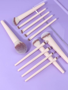 Top view of 10 professional makeup brushes with gradient fibers on purple background