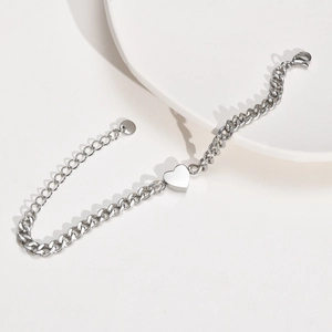 Detailed view of a silver stainless steel chunky chain bracelet with heart pendant