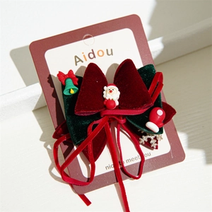 Detail of Christmas bow hair clip with Santa Claus charm and velvet ribbon texture