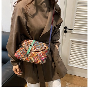Détail du sac à bandoulière tissé multicolore montrant la sangle en cuir texturé