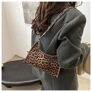 Detailed view of trendy leopard print baguette bag worn as a stylish underarm shoulder bag
