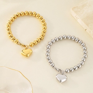 Détail de bracelets perlés en or 18 carats et argent avec pendentifs en cœur