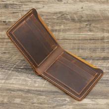 Detailed interior of vintage brown leather bi-fold wallet on rustic wood background
