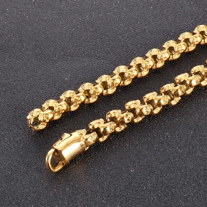 Macro shot of gold-plated skull link chain with detailed carvings and secure clasp