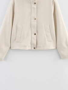 Detail of beige velvet jacket with gold metallic snap buttons and front pockets