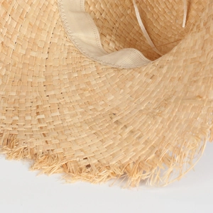 Détail d'un chapeau en raphia avec bord à franges et ruban de réglage intérieur