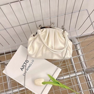 Top view of a white pleated dumpling bag with metal chain in a silver shopping cart