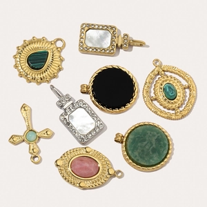 Assorted gold and silver pendants with natural stones like turquoise and onyx on a white background