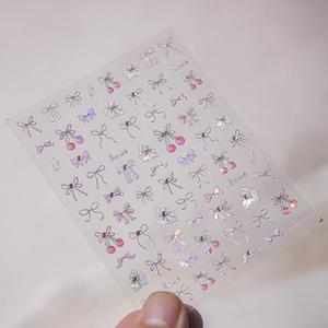Detail of pink bow and cherry nail stickers with holographic laser metallic finish