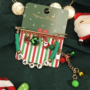 Détail du bracelet de Noël avec perles rouges vertes et breloques de lettres HAPPY