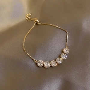 Detailed shot of gold plated four-leaf clover bracelet with square zircon and slide clasp