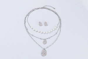 Detail of silver multi-layer necklace set with pearls and hammered texture pendants