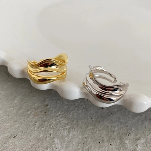 Detail of multi-layered irregular wave rings in polished gold and silver finish