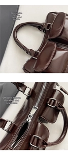 Detail view of smooth dual handles and metal zipper on retro dark brown leather saddle bag