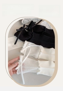 Detailed close-up of sweet lolita mid-calf socks with ruffles and delicate ribbon bows