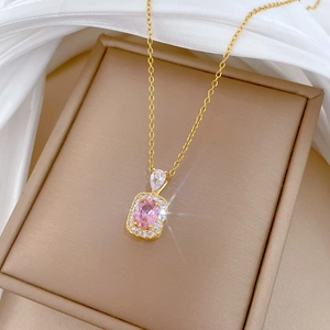 Detailed macro view of a gold pearl square pendant necklace with diamonds on silk