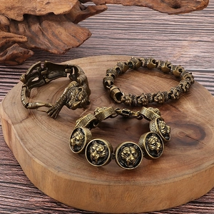 Retro tiger head bracelets in gold plating finish displayed on a natural wood base