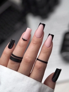 Close-up of long black and white French manicure nails featuring sparkling rhinestones