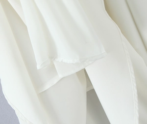 Detailed close-up showing the soft white chiffon fabric and fine hem stitching on the dress