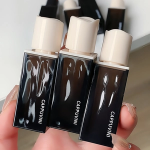 Detailed view of three matte velvet lip glazes held by a hand with manicured nails