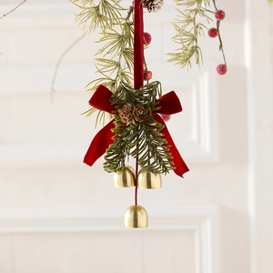 Weihnachtskranz mit goldenen Glocken, roter Samtschleife und Zapfen an einem Zweig