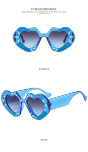 Detail of heart-shaped sunglasses with blue rhinestones and gradient lenses