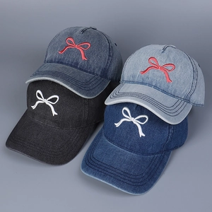 Detaillierte Ansicht von vier bunten Denim-Baseballkappen mit süßen Schleifen-Stickereien