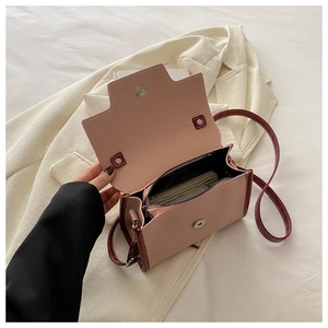 Detail view of pink and burgundy crossbody bag interior with secure zipper pocket