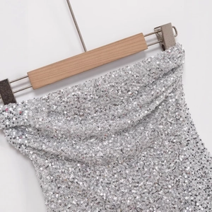 Top a fascia con paillettes argento scintillanti su gruccia in legno sfondo bianco