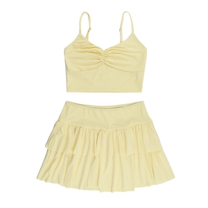 Flat lay of a yellow two-piece summer set featuring a crop camisole and ruffled mini skirt