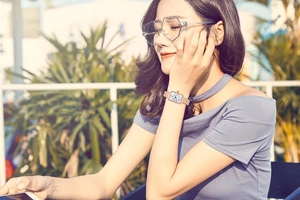 Detail shot of a square rose gold watch with Arabic numerals and stylish eyeglasses