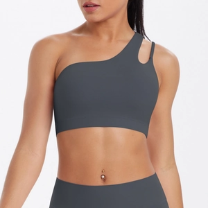Detail of dark grey one-shoulder sports bra with asymmetrical straps and matte texture