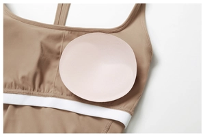 Detail showing removable round pads and elastic band of a brown recycled tennis dress