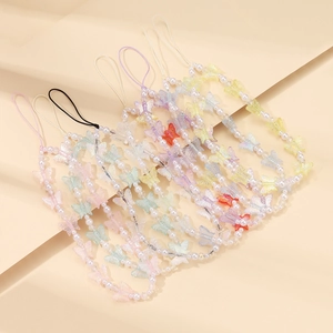 Detailed view of colorful translucent butterfly beads and white pearls on handmade phone straps