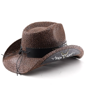Détail d'un chapeau de cowboy en paille avec bandeau clouté noir et broderie blanche