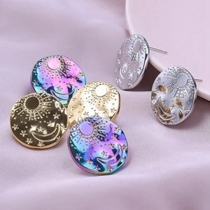 Macro view of stainless steel sun moon and star stud earrings on purple silk background